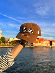 "ARGH-ARGH/SEAL" embroidered Cap design by Natali Koromoto. Made by Ho Hos Hole in The Wall. Waxed 100% cotton. Made in NYC.