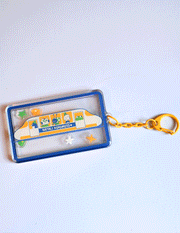 Passengers shaker acrylic keychain by Natali Koromoto featuring animal characters on a Shinkansen train with star and flower charms, double-sided design