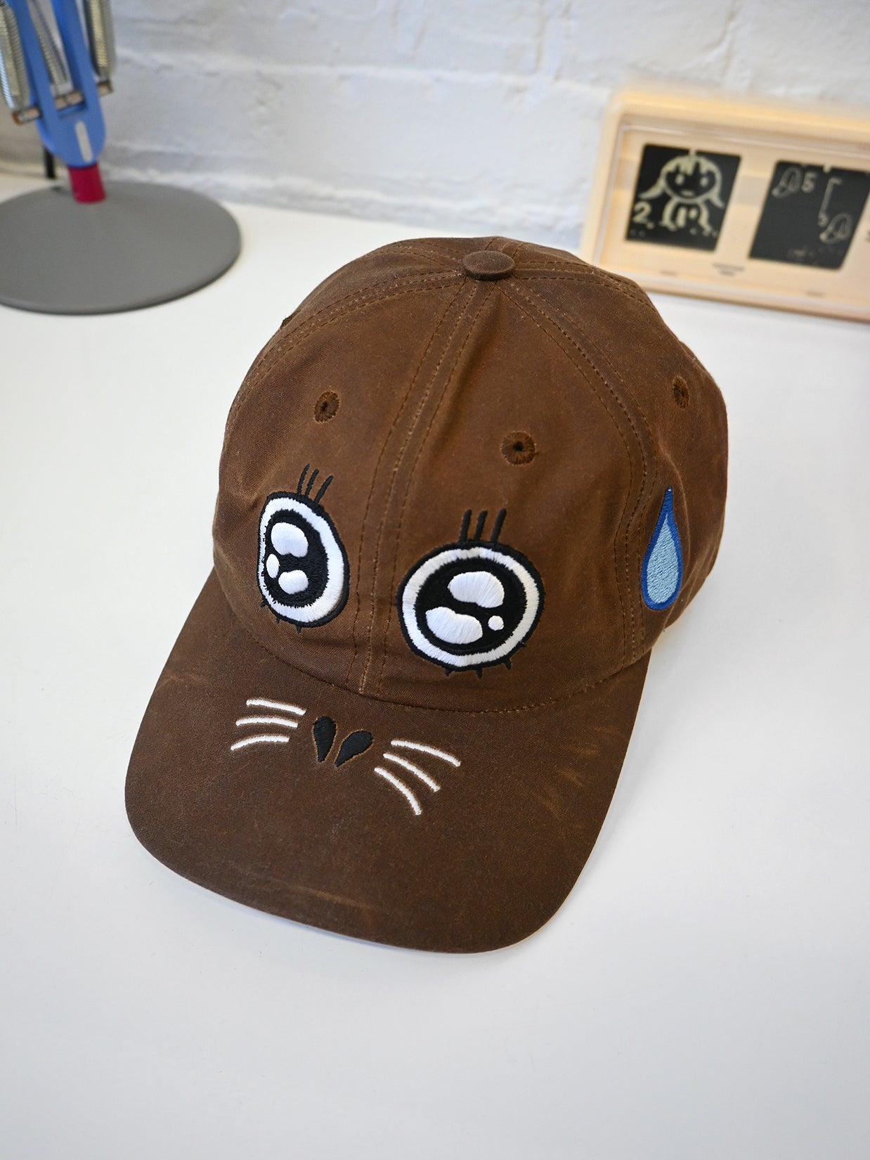 "ARGH-ARGH/SEAL" embroidered Cap design by Natali Koromoto. Made by Ho Hos Hole in The Wall. Waxed 100% cotton. Made in NYC.