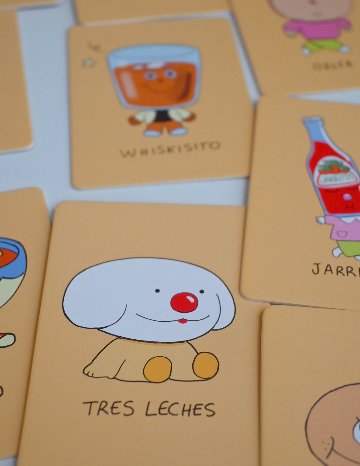 "Los Alfabetos" is a memory card matching game set of 26 pairs of Latin food characters. Designed by illustrator Natalí Koromoto Martínez.