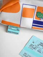 "Passengers" pencil pouch by Natali Koromoto showing closeup of the brand tag, which is a "Reserved Ticket" for "The Passengers".
