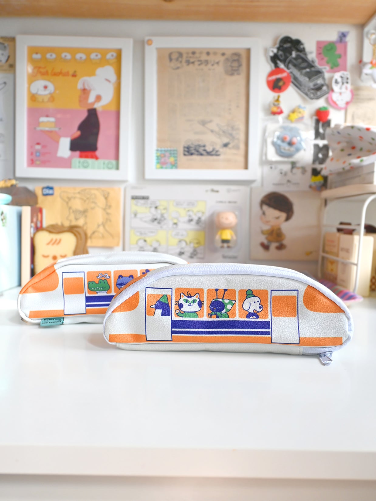 Train-shaped pencil case on a white surface with a colorful background featuring posters and toys.