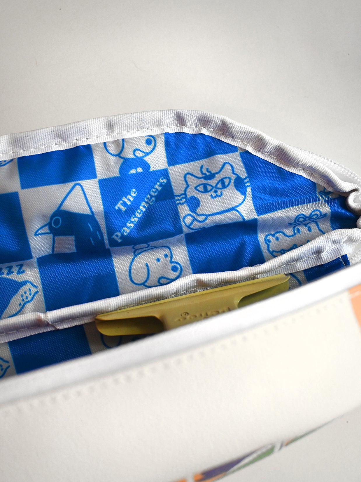 Blue and white patterned pouch with visible brand logo on a light gray background