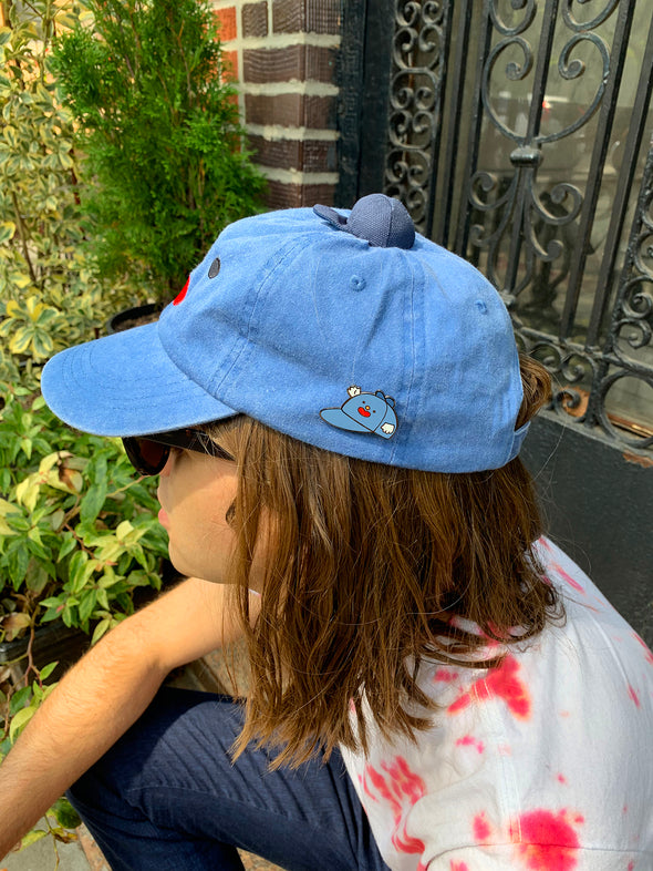 Home to the original hat wearing a hat, "Hat on Hat," designed by artist Natali Koromoto Martinez. This is an enamel pin of the original "Hat on Hat" illustration.